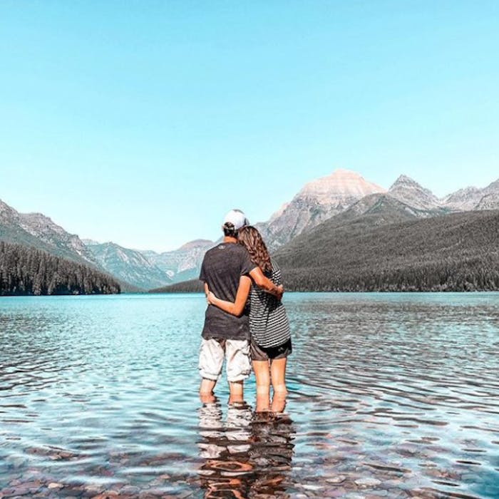 Pick up truck pulling a Keystone Montana fifth wheel on the left. Janae and Tucker standing in a mountain lake on the right.