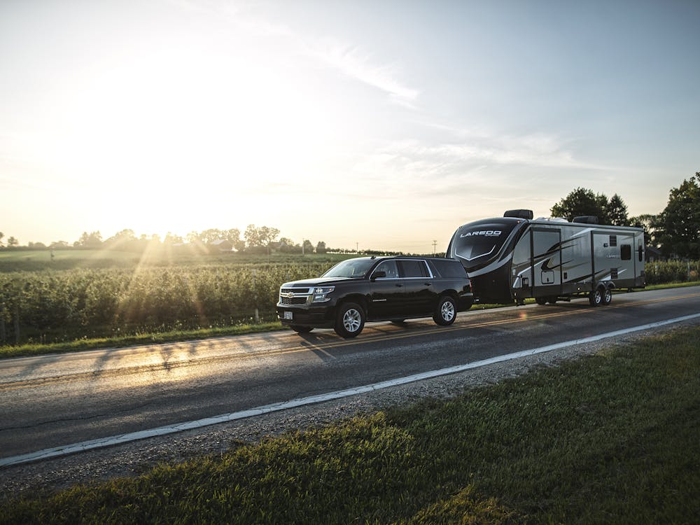 Truck and RV traveling on a country road with sunsetting