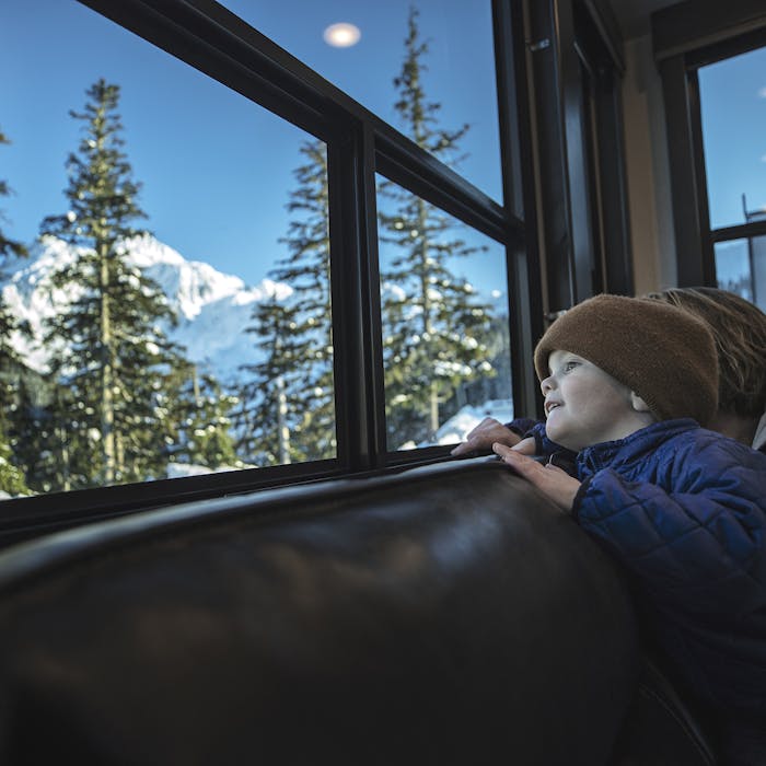 Kids looking out a Montana at snow on the ground.