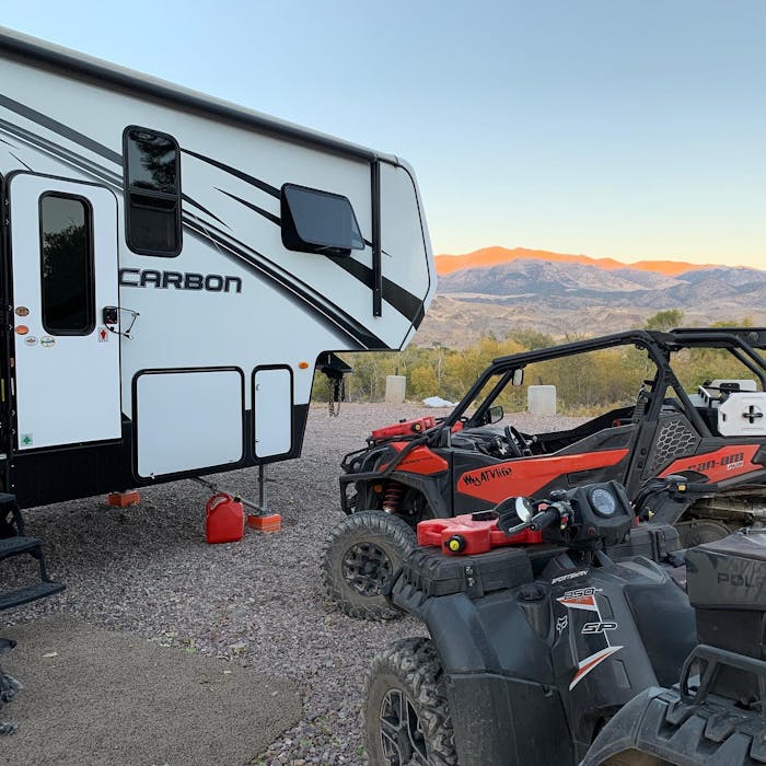carbon toyhauler beside a red atv