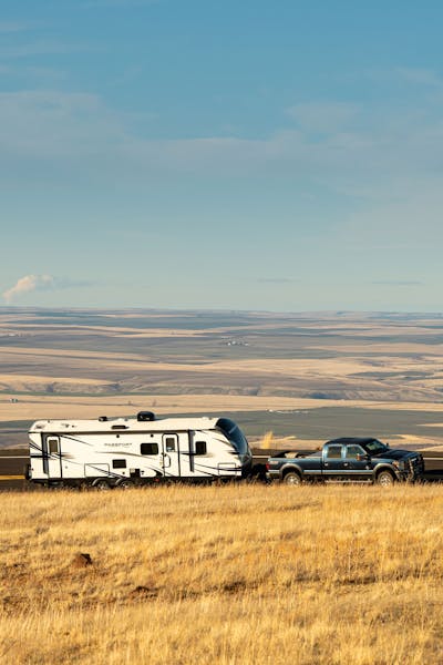 Keystone Passport travel trailer being pulled down a county road in Oregon.