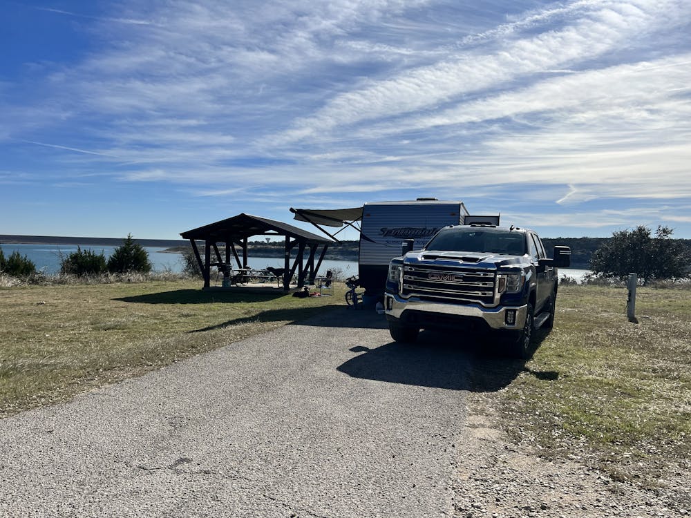 Springdale Camper and GMC set up at campsite near a lake