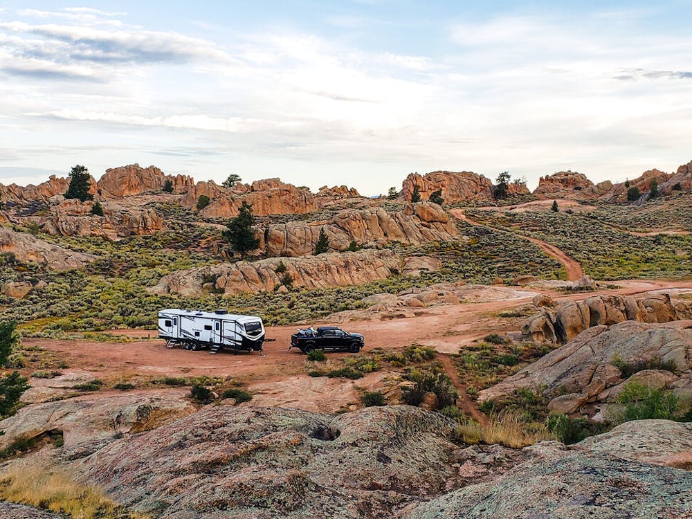 outback travel trailer with a black truck alone in the desert