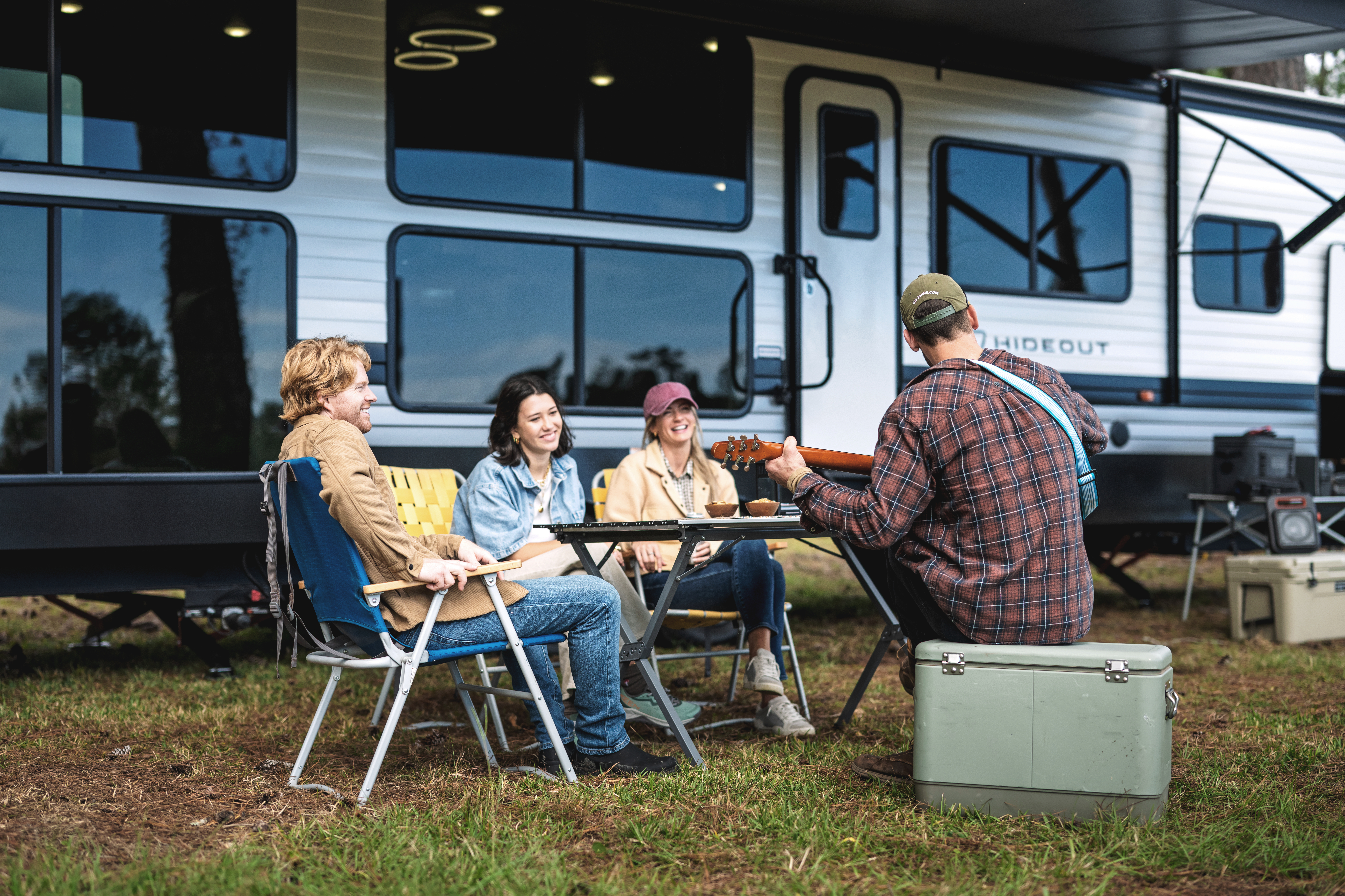 Group of friends sitting outside listening to music