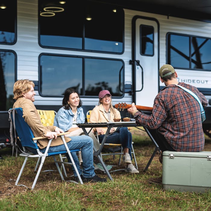 Group of friends sitting outside listening to music