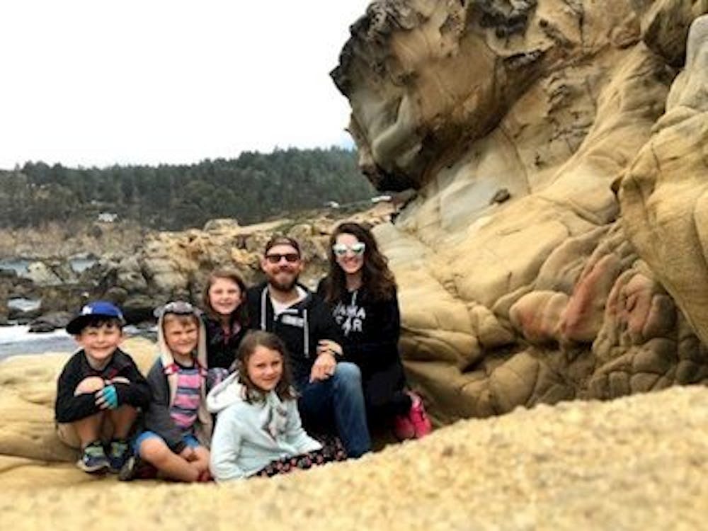Family in front of cliff and lake