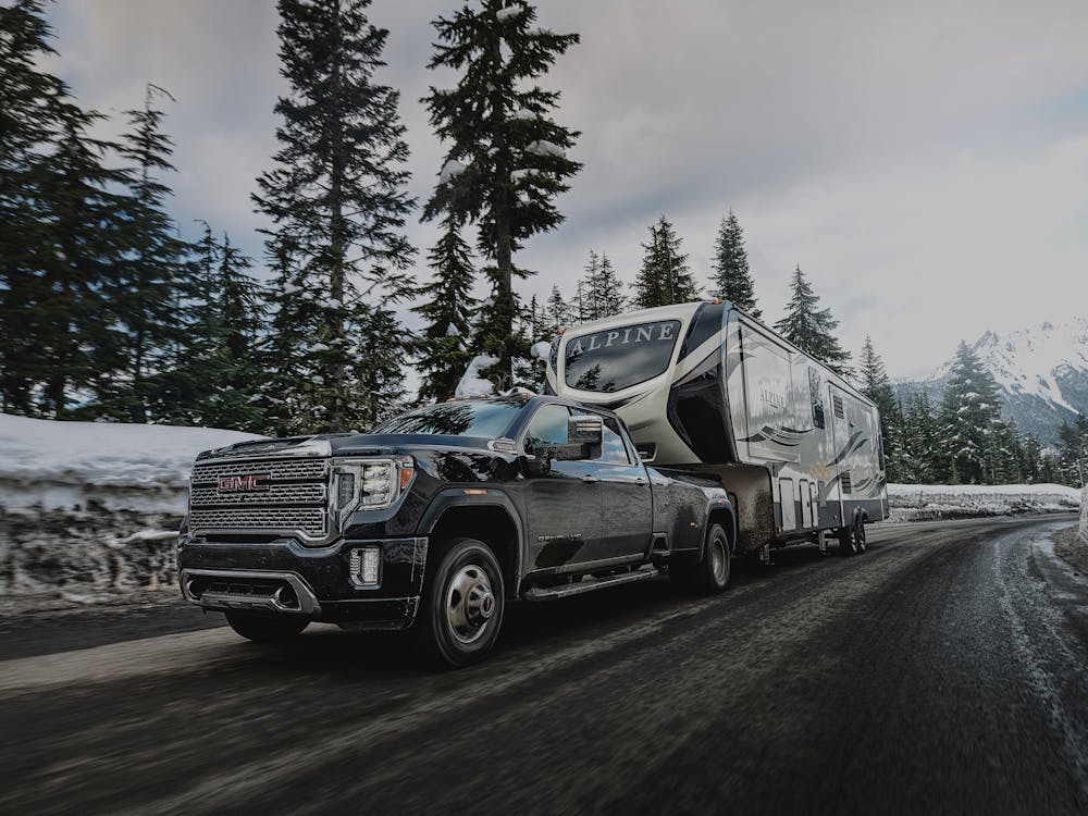 GMC towing an Alpine in snow covered mountains